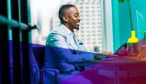 a man smiling in front of his computer