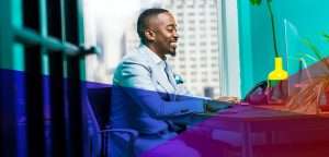 a man smiling in front of his computer