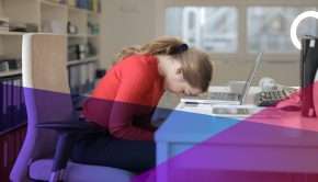 A dejected woman with her head on a desk