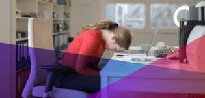 A dejected woman with her head on a desk