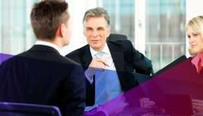 hiring managers sitting across the tab from a job candidate