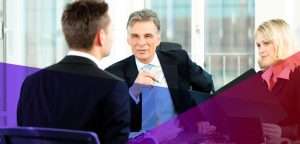 hiring managers sitting across the tab from a job candidate
