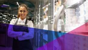 un employé de magasin souriant dans une allée d'épicerie