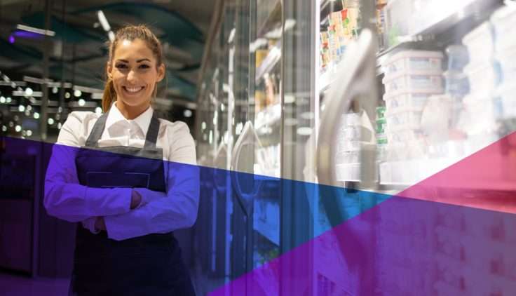 a store clerk smiling in a grocery aisle
