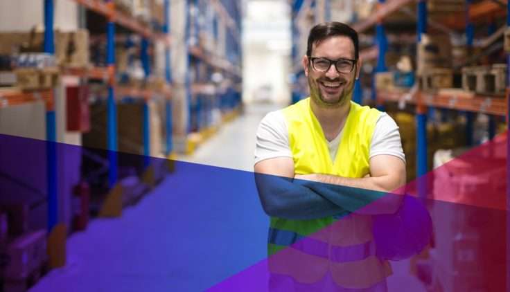 man in a safety vest with crossed arms in a warehouse