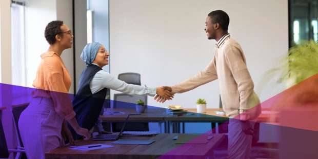 a man shaking hands with a hiring manager across a desk