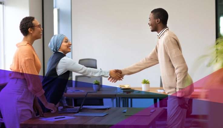 a man shaking hands with a hiring manager across a desk